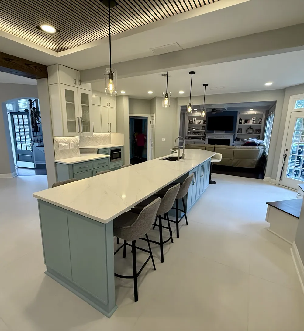 Open modern kitchen in soft blue and white tones, viewed from the living side.
